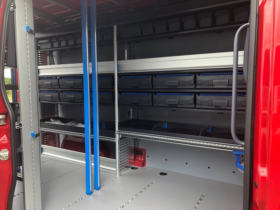 Regalsystem mit blauen Halteschienen im Laderaum eines roten Transporters