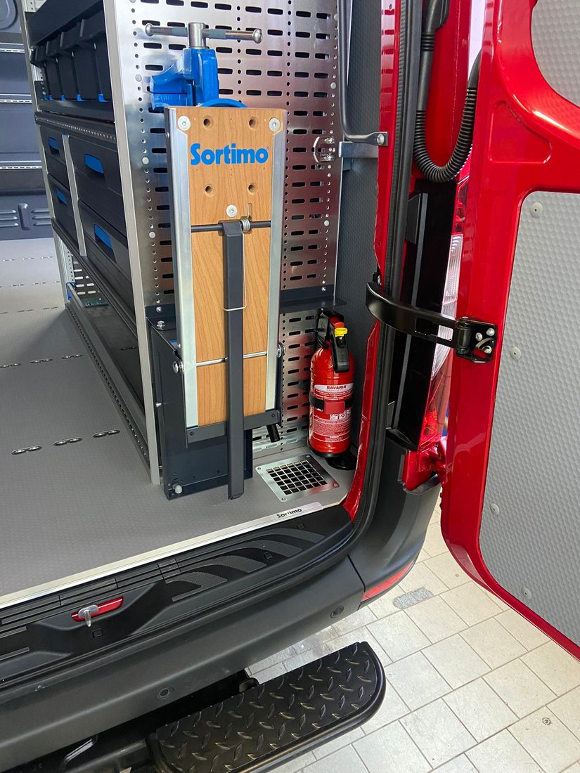 Blick durch die geöffnete Seitentür auf Regal und Schublade